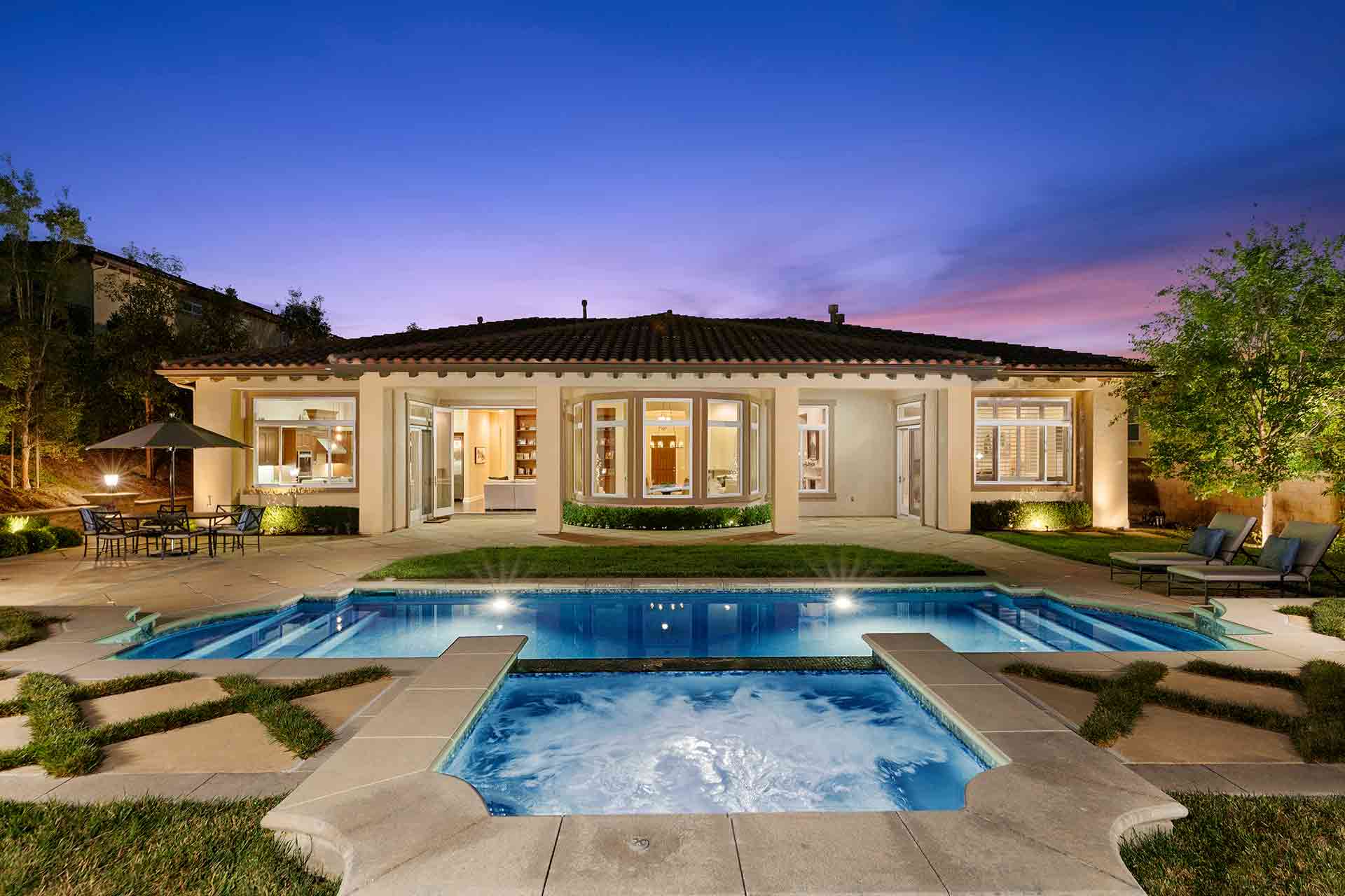 A swimming pool in front of a luxury house
